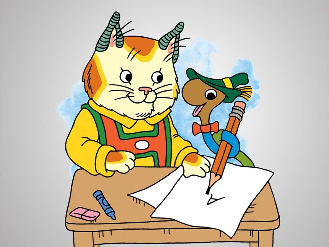 Huckle Cat, a cat wearing a shirt, and Lowly Worm, a worm wearing a bowtie and hat, sit at a desk.