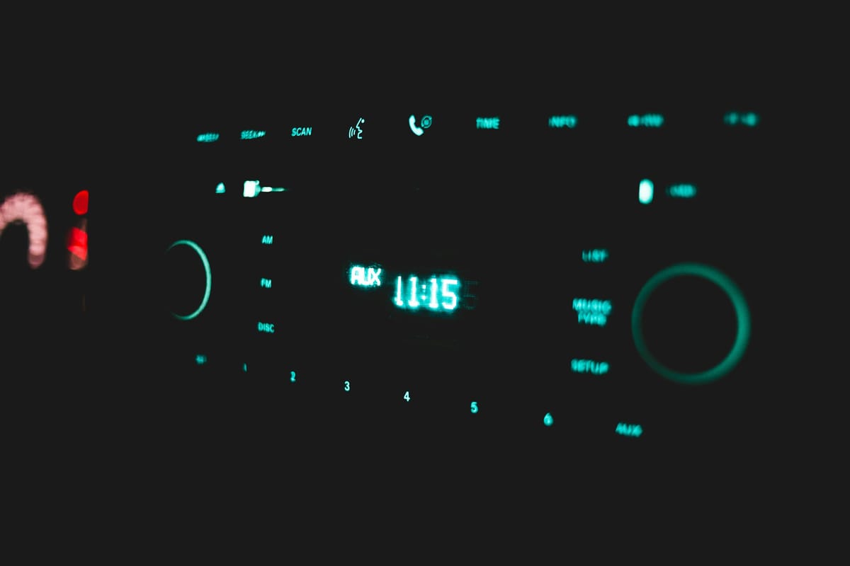 Lit up car radio controls in center console at night.
